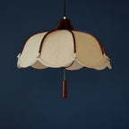 Beige fabric pendant lamp with scalloped edges, brown canopy, and vertical hanging finial