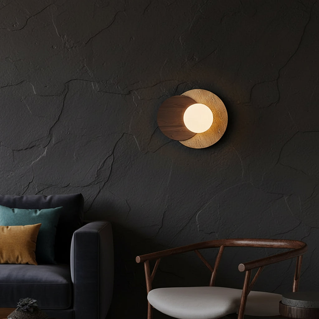 Circular layered wall sconce with travertine-look finish and lit globe