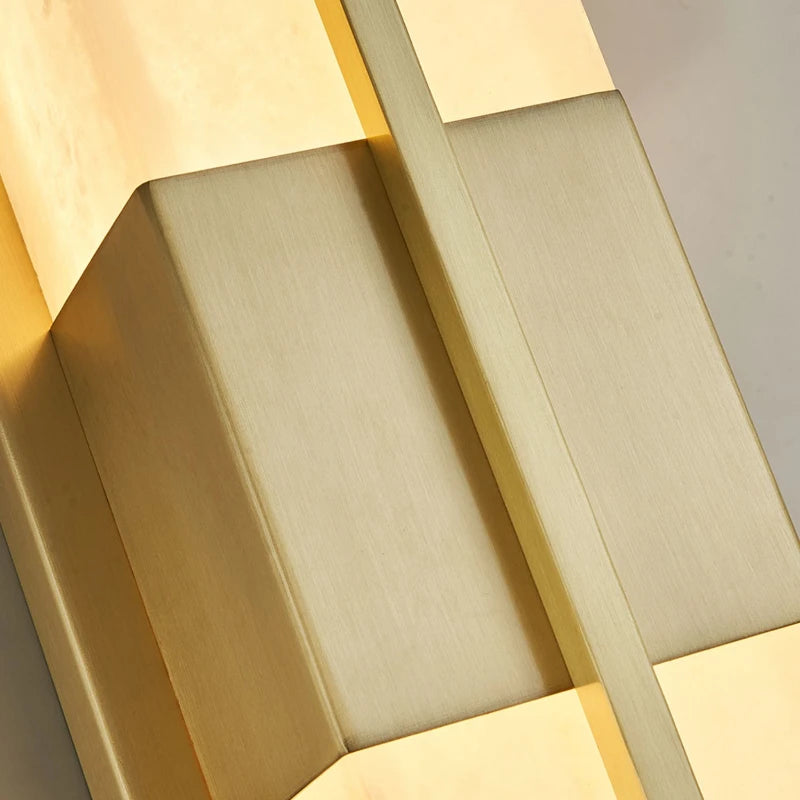 Close-up of gold vertical wall sconce frame with frosted glass strip panels