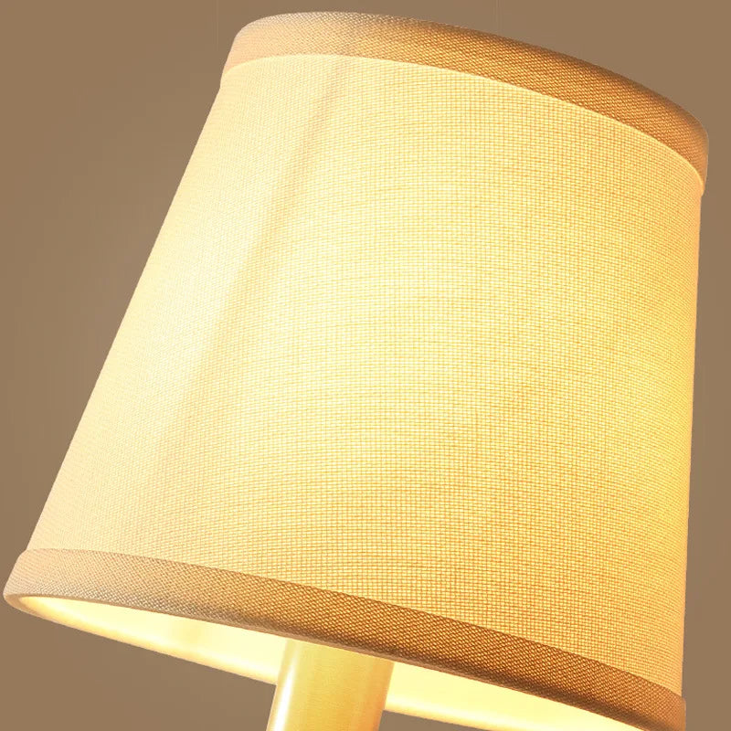 Conical fabric shade with warm light glow on a brass wall sconce