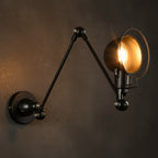 Black dome swing-arm wall sconce with warm lit bulb and round wall plate