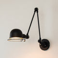 Black dome swing-arm wall sconce with adjustable arms and hinged lamp head