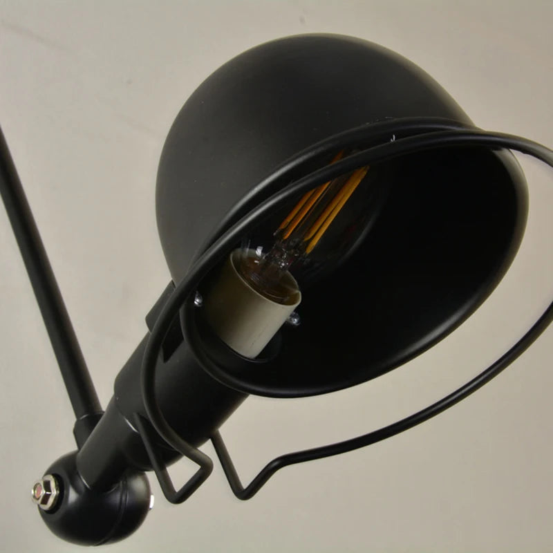Close-up of black dome swing-arm wall light with exposed bulb and metal arm