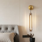 Brass cylindrical linear sconce with clear tubular glass diffuser on wall mount