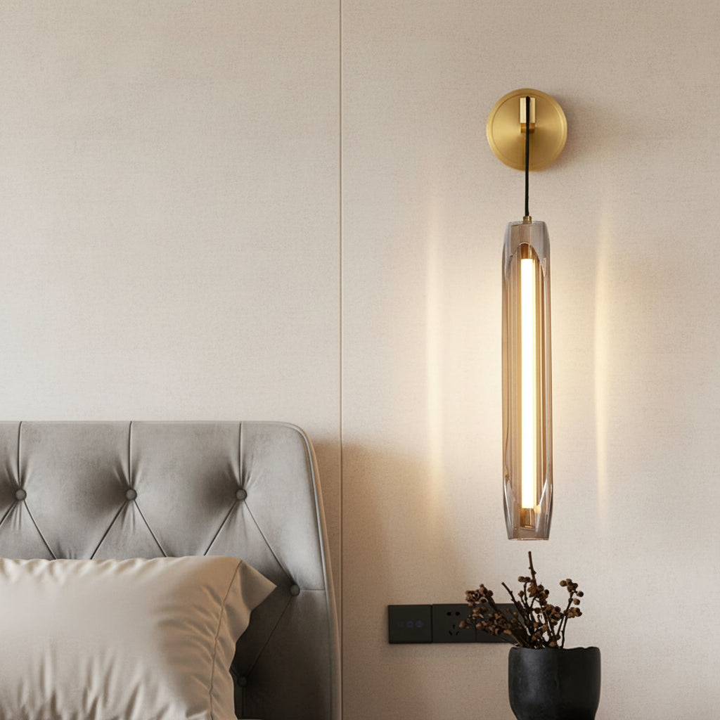 Brass cylindrical linear sconce with clear tubular glass diffuser on wall mount