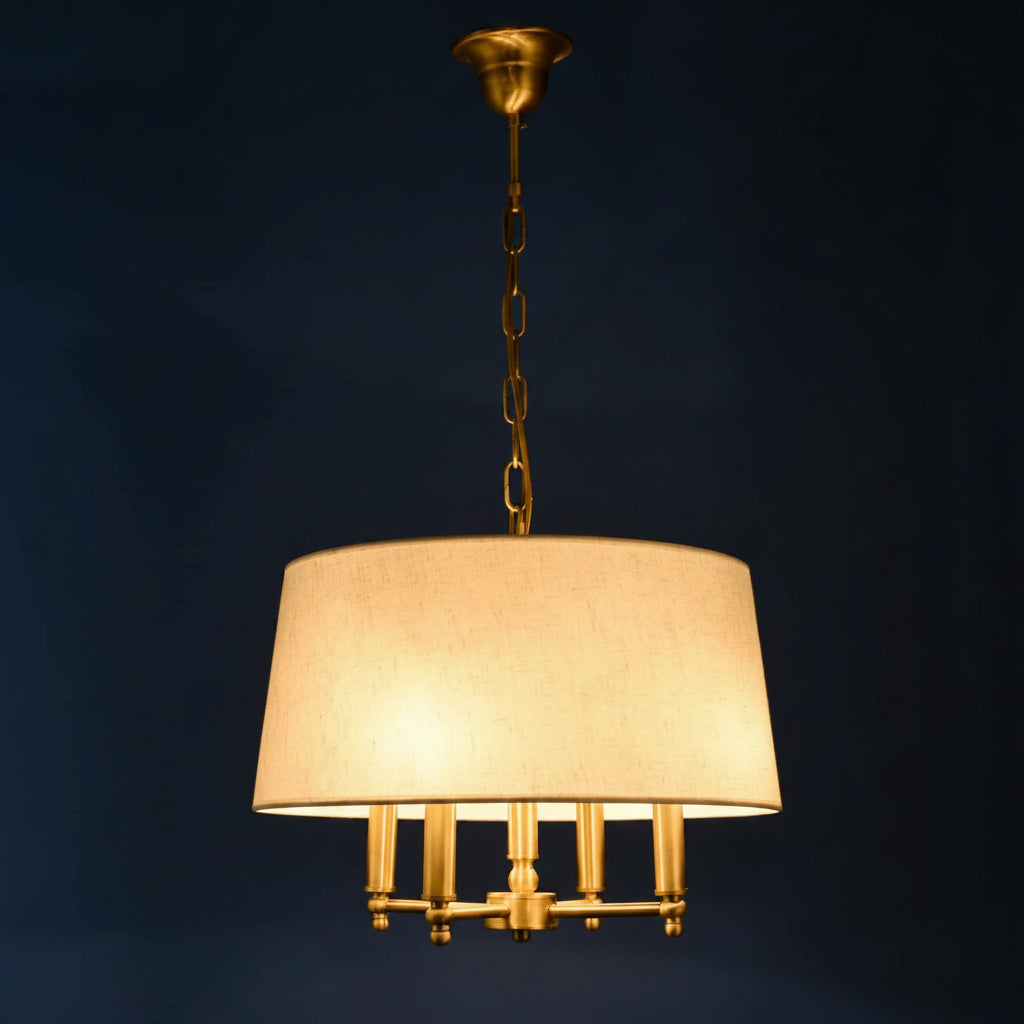 Fabric drum pendant light with white shade, gold chain, and multi-bulb candle-style base