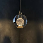 Teardrop pendant light with smoked glass shade and moonlike globe inside, dark metal mount