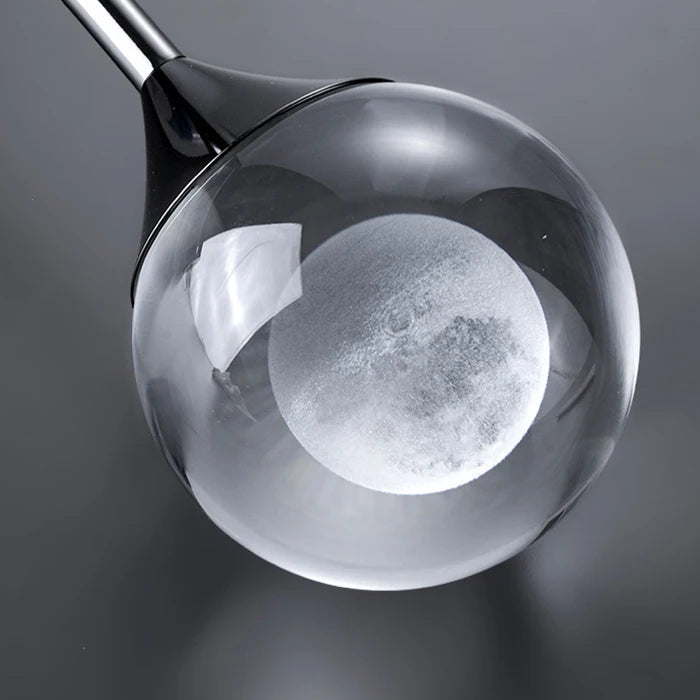 Close-up of teardrop pendant light showing reflective smoked glass globe and circular inner glow