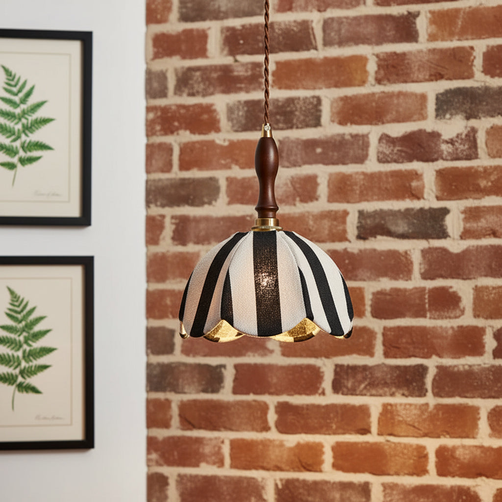 Black-and-white striped fabric pendant shade with brass rim and brown stem.