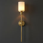 Gold vertical wall sconce with cylindrical frosted shade and circular backplate