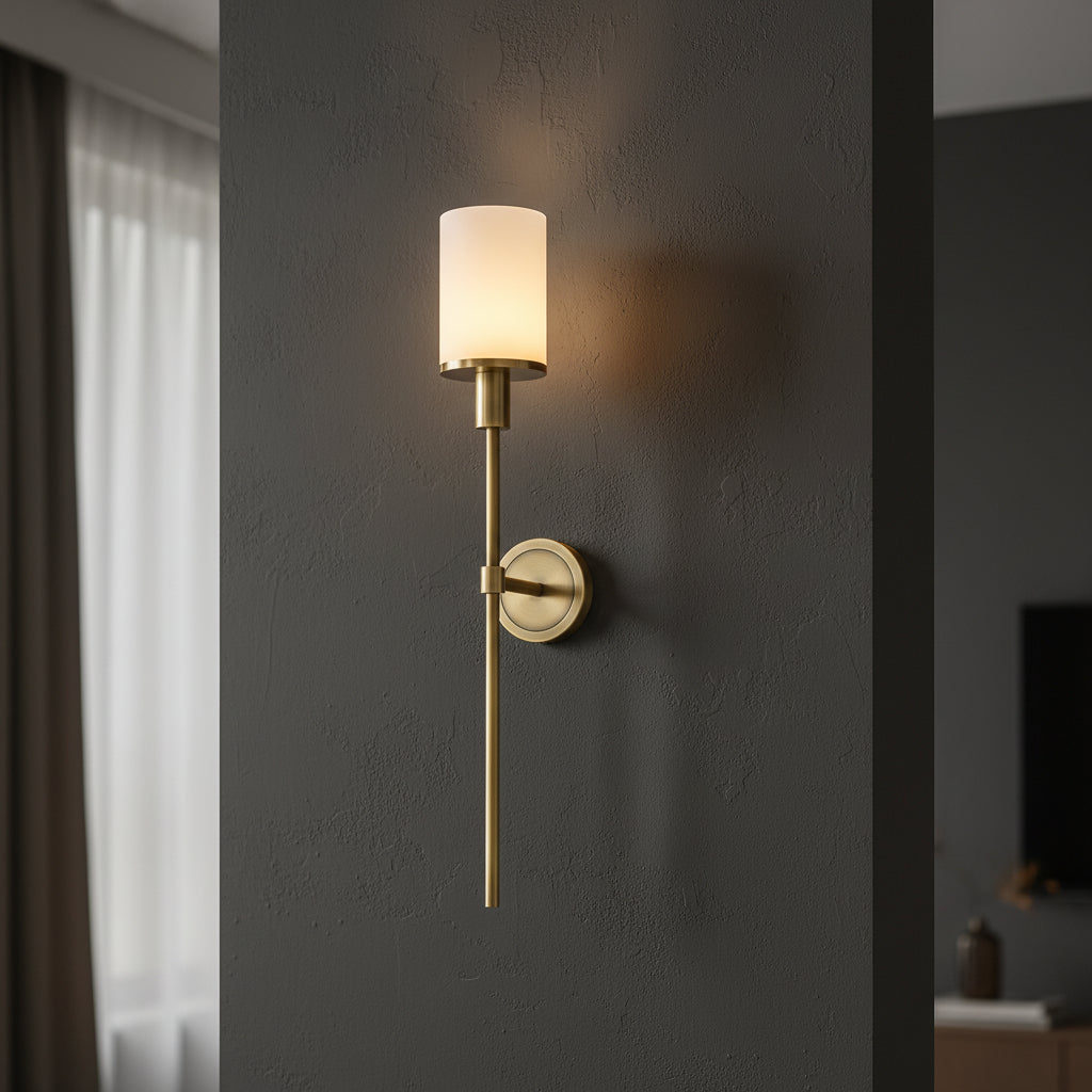 Gold vertical wall sconce with cylindrical shade and round backplate on rod