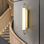 Long cylindrical opal wall sconce with gold arched frame and two glass diffusers, warm