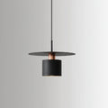 Single black cylindrical pendant light with a warm glowing bulb