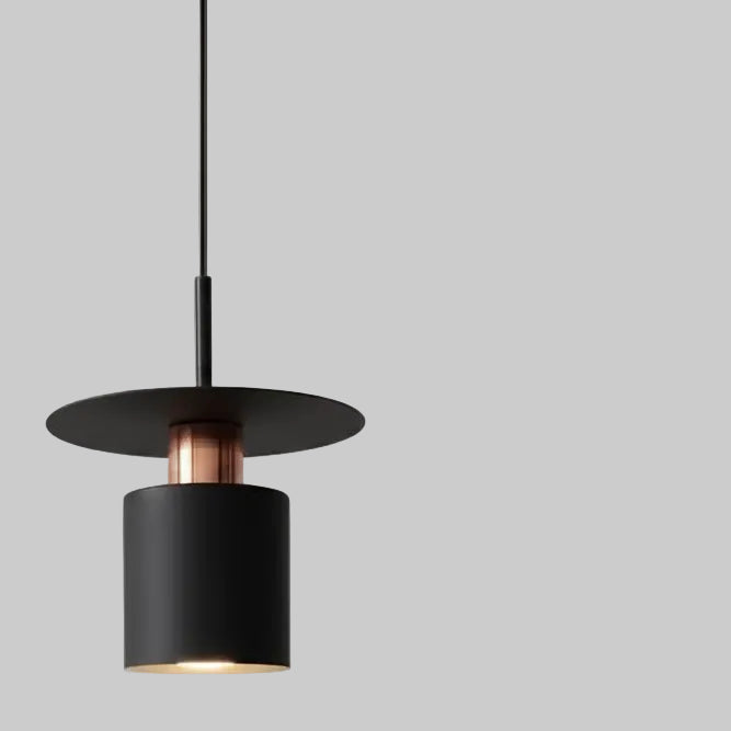 Black cylindrical pendant light with warm glowing bulb and metal top band