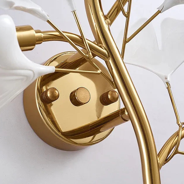 Close-up of gold ginkgo leaf wall sconce base and acrylic petal arms