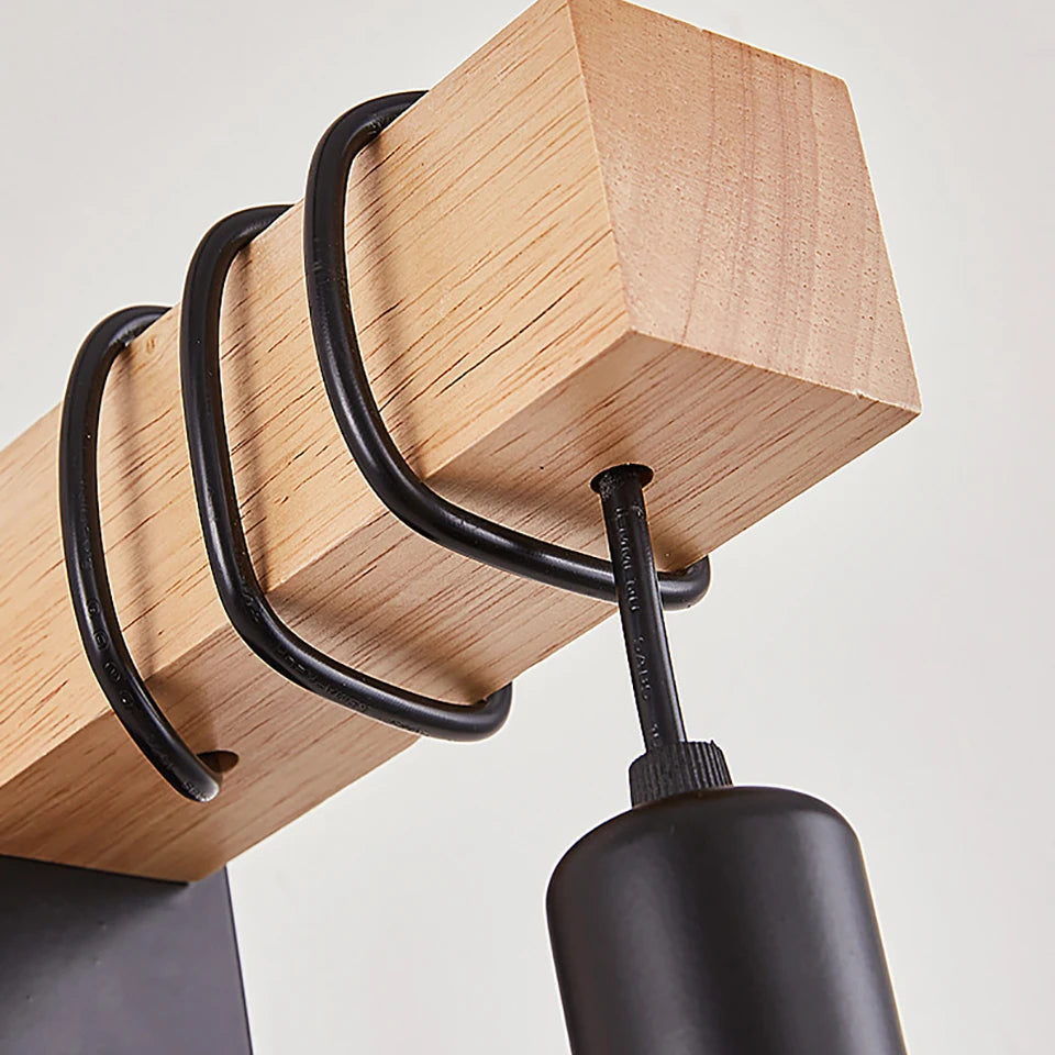 Close-up of rustic wall sconce: light wood backplate and loops with dark metal drop socket