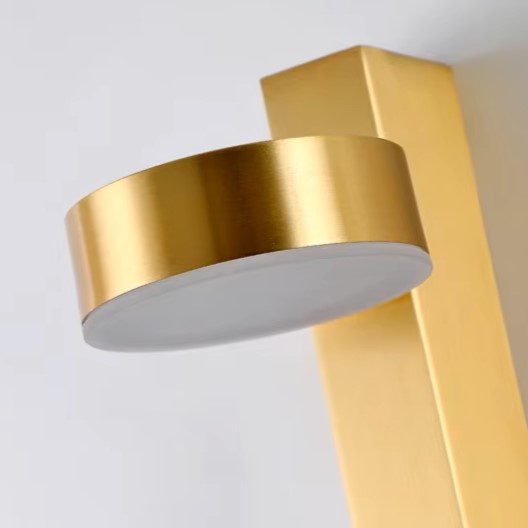 Gold cylindrical wall sconce shade with angled head detail for vertical mounting