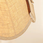 Close-up of beige fabric shade with stitched scalloped petal edge and brown trim