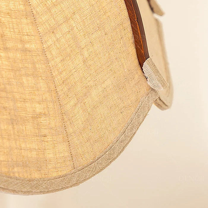 Close-up of beige fabric shade with stitched scalloped petal edge and brown trim