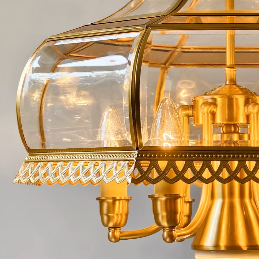 Close-up of gold scalloped base and clear hexagonal lantern with candle-style bulbs.