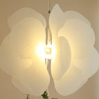 Close-up floral acrylic pendant light with layered petals and illuminated bulb
