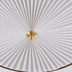 White pleated UFO-style lamp shade with gold bulb holder