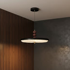 Black UFO-style pleated pendant light with round ribbed shade and wood stem