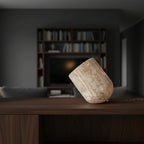 Travertine table lamp with slanted cylindrical beige stone shade and braided power cord