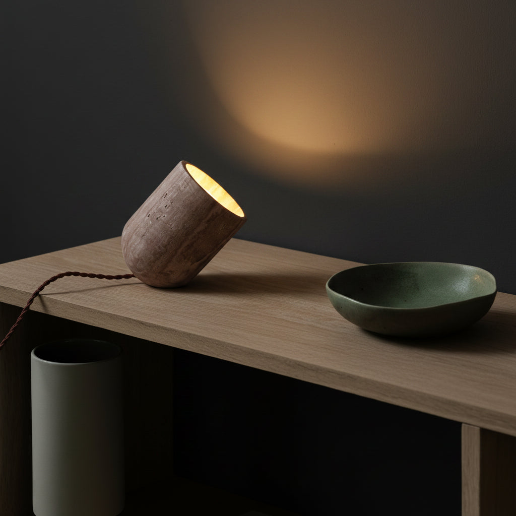 Travertine slanted table lamp with warm-glow opening, beige stone base and braided cord
