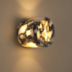 Marble cylinder wall light, warm glow through round stone-pattern shade