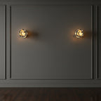 Two marble cylinder wall lights on panelled wall with warm light