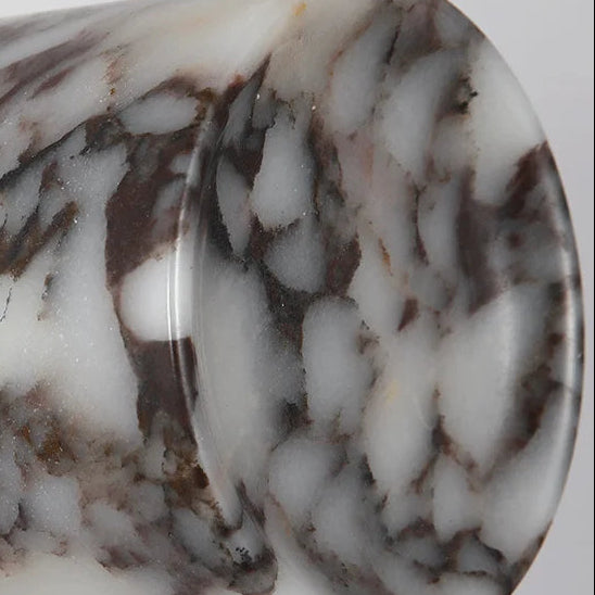 Marble cylinder wall light close-up of round white-and-brown stone shade