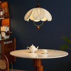 Fabric petal pendant light with layered cream shade, gold ring, and brown hanging detail