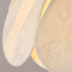 Close-up fabric petal shade in cream with subtle floral pattern texture