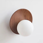 Walnut wall sconce with opal globe glass shade and dark circular backplate