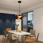 Brown wood curved pendant light with warm-lit bulbs above a dining table