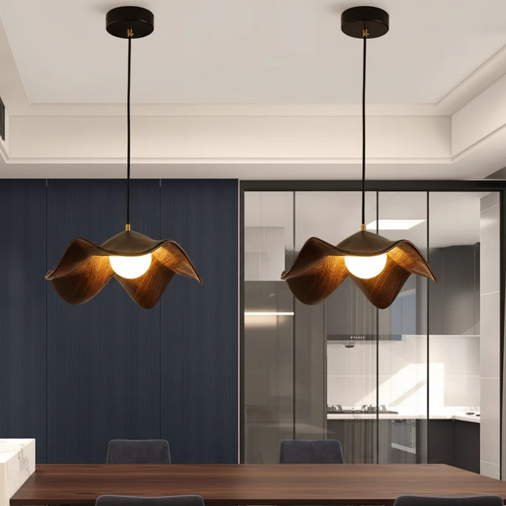 Pair of curved wooden pendant lights with warm glowing bulbs and dark cords