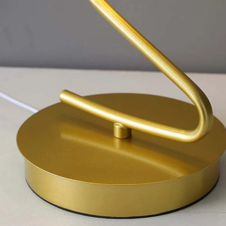 Gold round base and curved lamp stem with integrated power cord