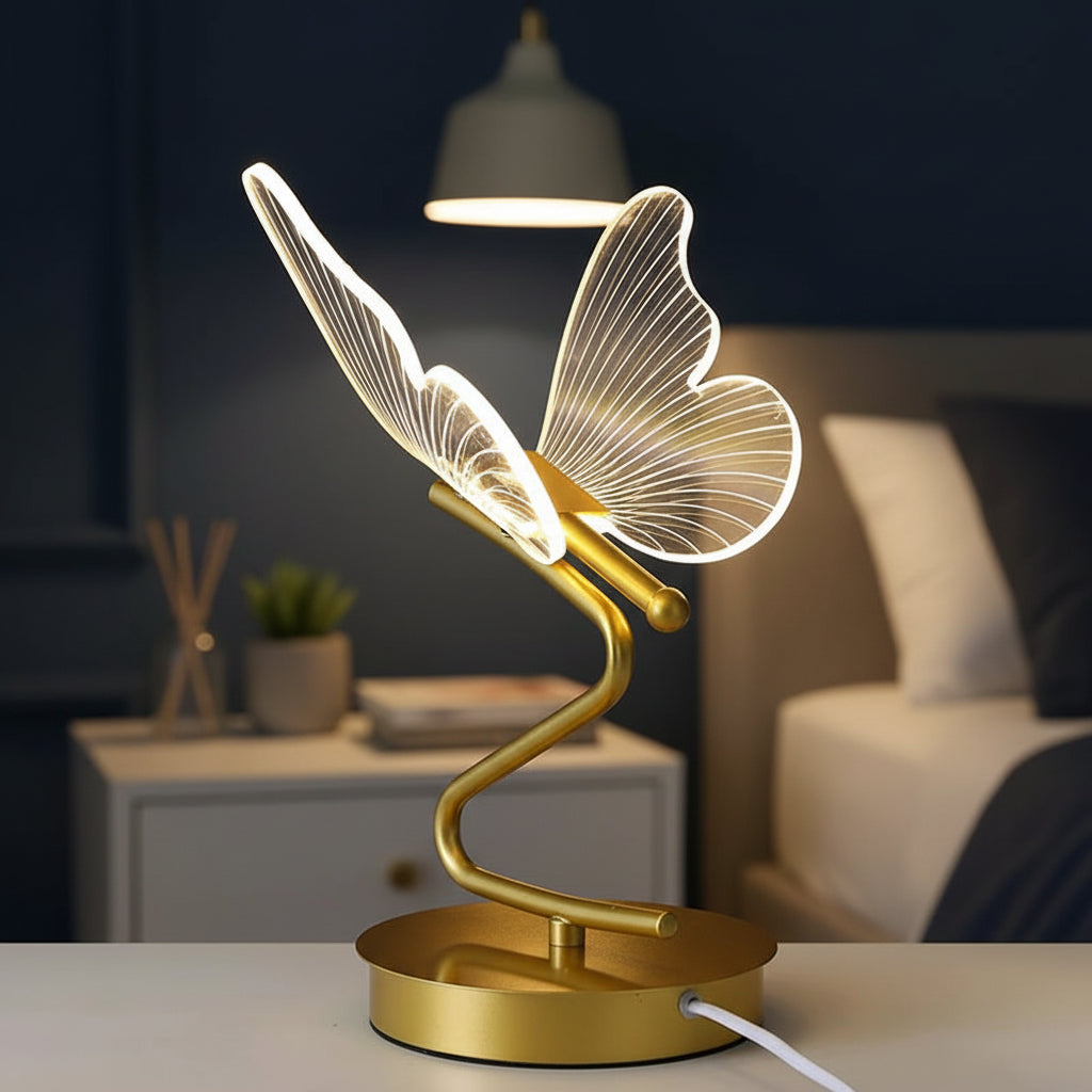 Gold butterfly table lamp with glowing wire wings on a round base and curved stem