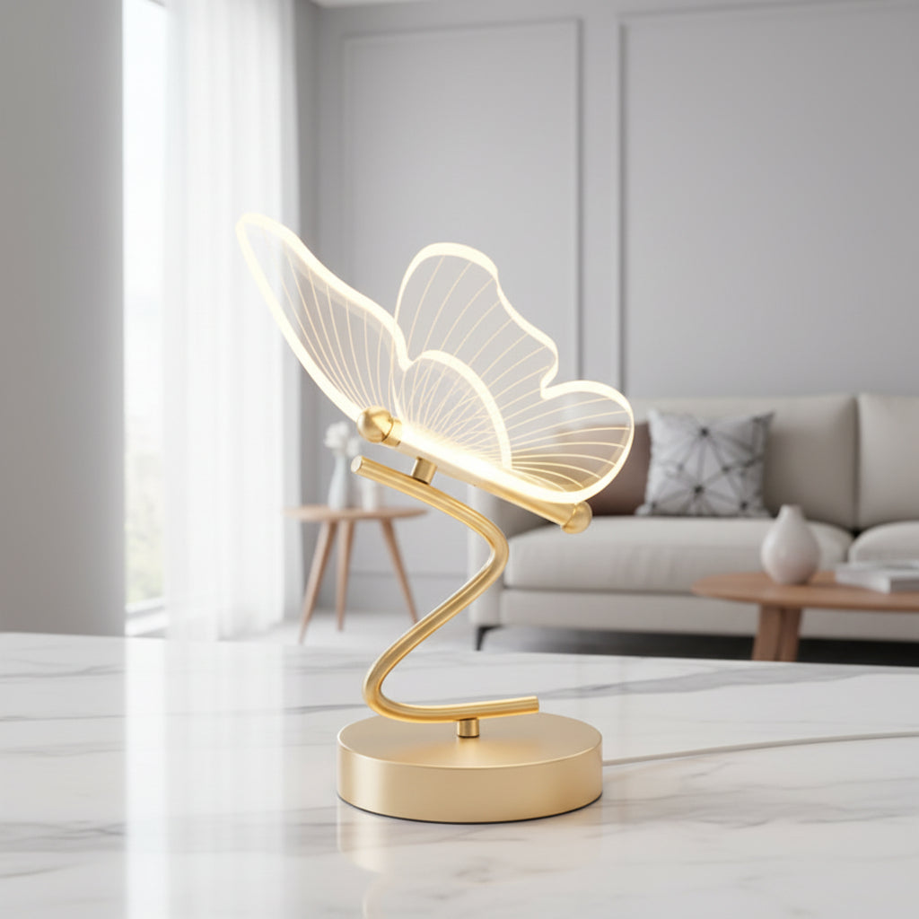 Gold butterfly LED table lamp with lit wing shade on a round pedestal base