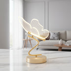 Gold butterfly LED table lamp with lit wing shade on a round pedestal base