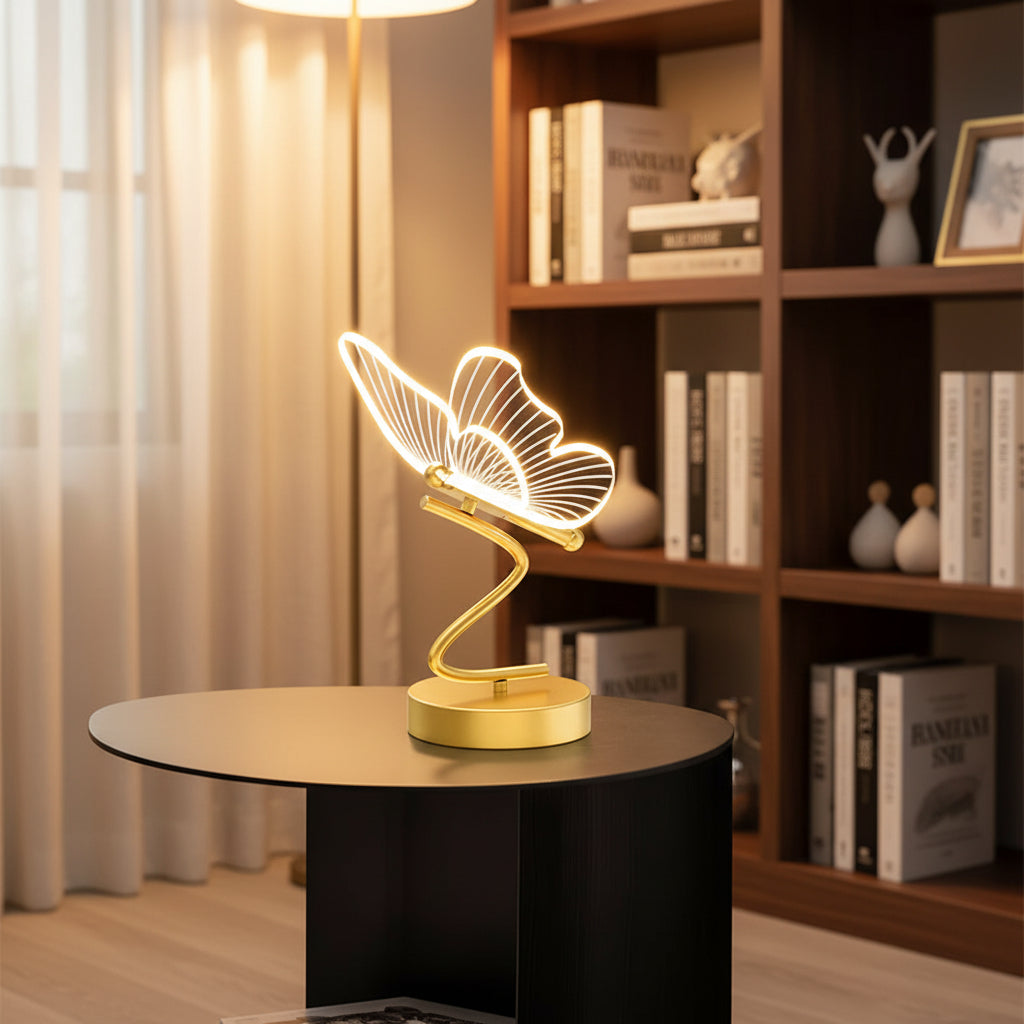 Butterfly table lamp with glowing wire wings on a gold stand and round base