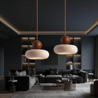 Stacked pendant light pair with speckled travertine dome shades and walnut wood caps