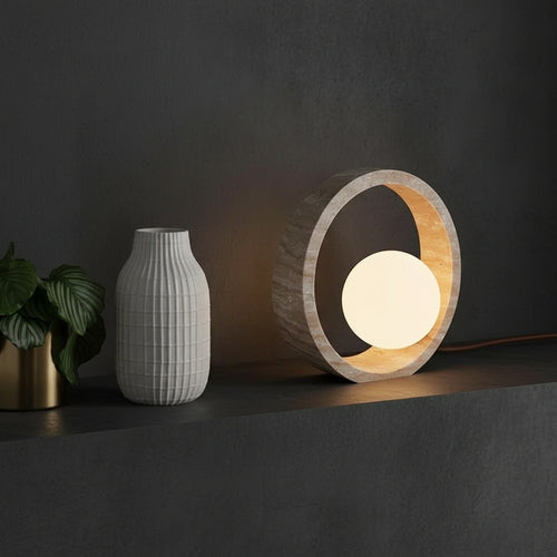 Travertine ring table lamp with illuminated globe set in sand-textured ring