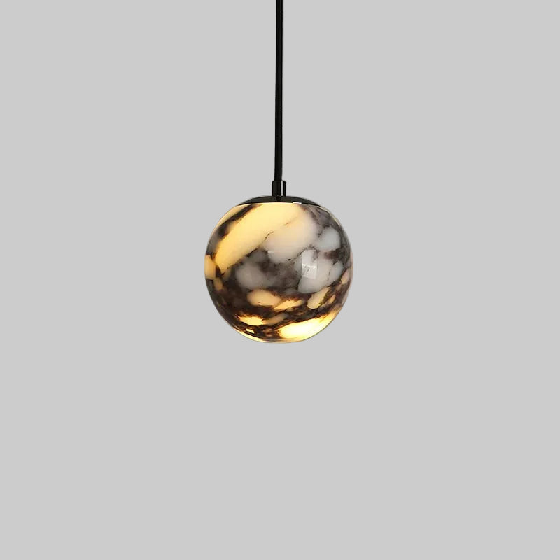 Marble glass orb pendant light with black cord and polished metal top
