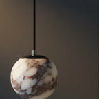 Marble glass orb pendant light with black cord and metal top, white-and-brown