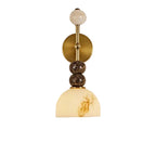 Gold-toned brass round backplate wall sconce with stacked stone spheres and dome shade