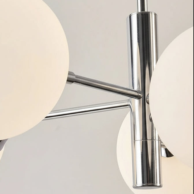 Close-up of chrome arm and frosted glass globe shades on a globe chandelier