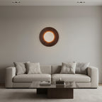 Brown circular wall light sconce with backlit travertine disk and warm glow ring