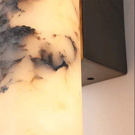 Close-up of cylindrical marble diffuser for a wall light with black speckle pattern